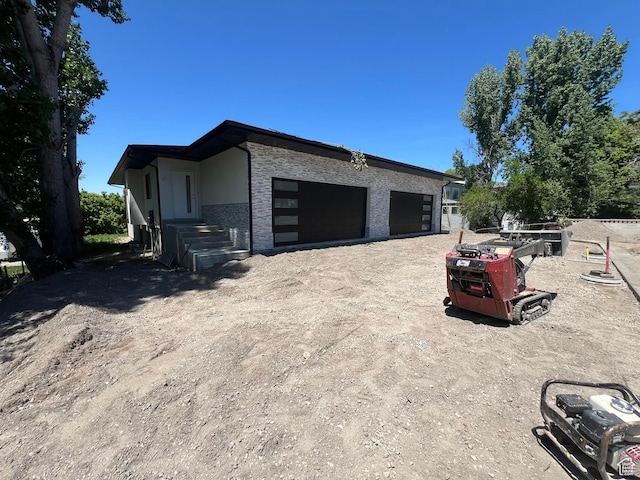 7230 S 525 E, Midvale, UT 84047 - view of property exterior featuring a garage and stone siding