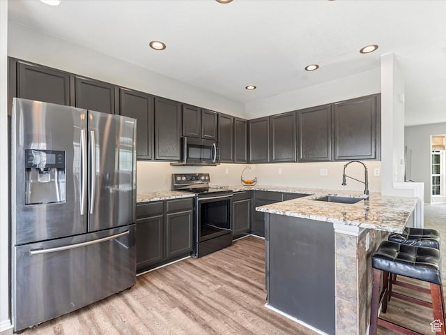 955 E Senior Band, Draper, UT 84020 - kitchen featuring stainless steel appliances, a sink, a peninsula, light wood finished floors, and light stone counters