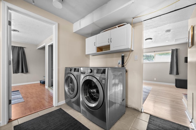 4314 S 615 E, Millcreek, UT 84107 - laundry room featuring washing machine and clothes dryer, cabinet space, light wood-style floors, a textured ceiling, and baseboards