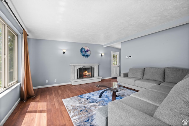4314 S 615 E, Millcreek, UT 84107 - living room with wood finished floors, baseboards, a lit fireplace, and a textured ceiling