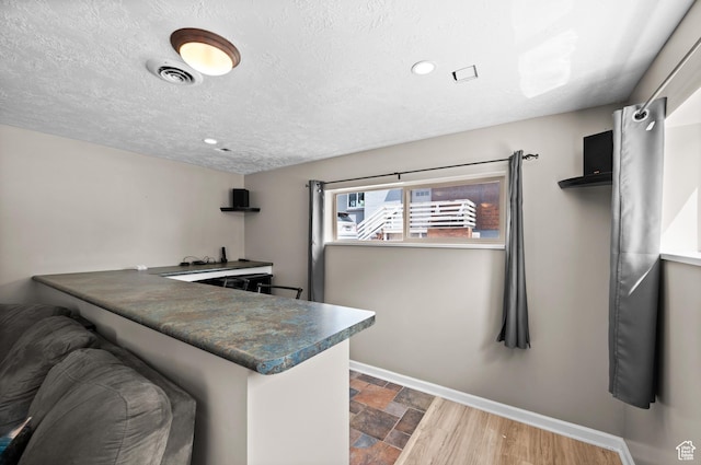 4314 S 615 E, Millcreek, UT 84107 - kitchen featuring baseboards, dark countertops, stone finish flooring, recessed lighting, and a peninsula
