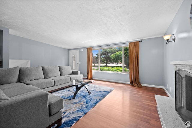 4314 S 615 E, Millcreek, UT 84107 - living area featuring wood finished floors, a textured ceiling, baseboards, and a fireplace with raised hearth