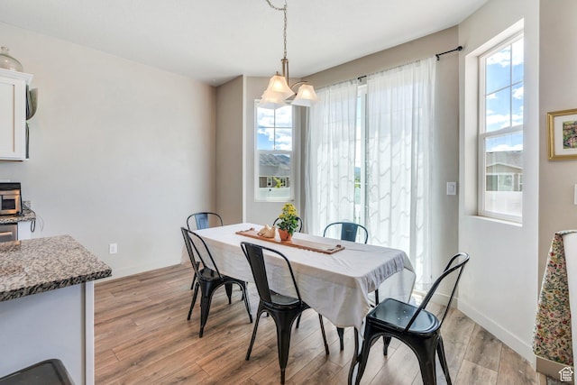 1460 E Lowe Peak Dr, Eagle Mountain, UT 84005 - dining room featuring light wood-type flooring, plenty of natural light, and baseboards
