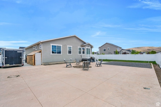 1460 E Lowe Peak Dr, Eagle Mountain, UT 84005 - back of property featuring a patio area, a fenced backyard, and stucco siding