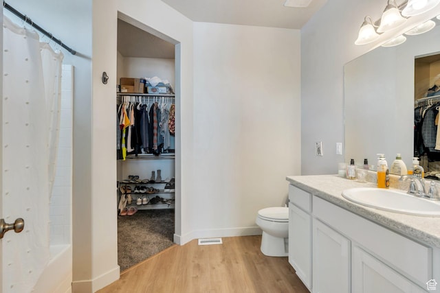 1460 E Lowe Peak Dr, Eagle Mountain, UT 84005 - full bath featuring wood finished floors, toilet, vanity, baseboards, and a walk in closet