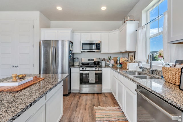 1460 E Lowe Peak Dr, Eagle Mountain, UT 84005 - kitchen with appliances with stainless steel finishes, a sink, white cabinets, light wood-style flooring, and recessed lighting