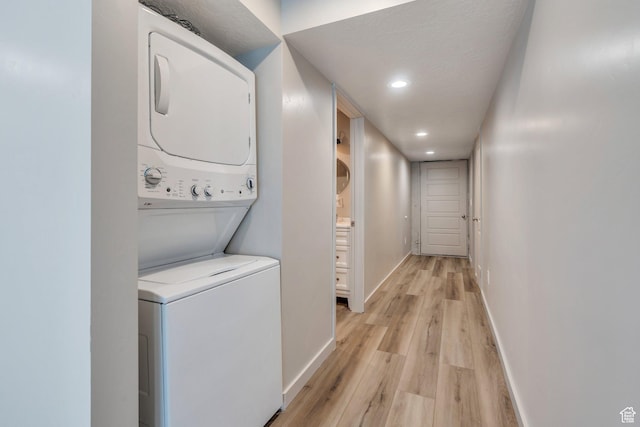 1460 E Lowe Peak Dr, Eagle Mountain, UT 84005 - laundry room with stacked washer and clothes dryer, light wood-style flooring, baseboards, and recessed lighting