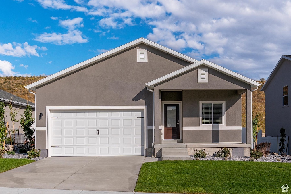 7174 Oquirrh Ranch Pkwy N, Eagle Mountain, UT 84005 - single story home with stucco siding, concrete driveway, an attached garage, and a front lawn