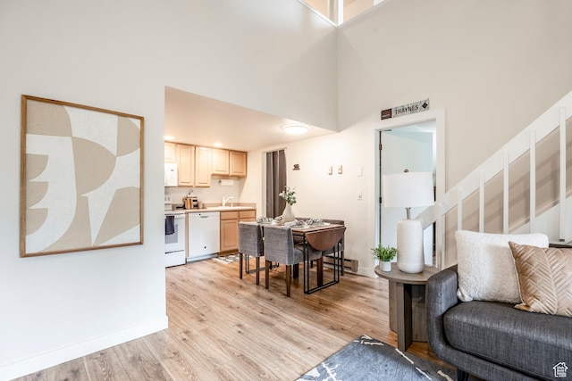 2025 S Canyon Resort Dr Unit F-8, Park City, UT 84098 - living area with a high ceiling, light wood-style floors, stairway, baseboard heating, and baseboards