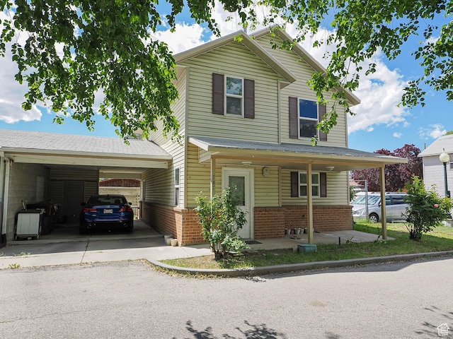 787 W Lennox St S, Midvale, UT 84047 - view of front of house featuring brick siding, an attached carport, asphalt driveway, and a porch