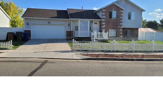 1004 N Sir Michael Dr, Salt Lake City, UT 84116 - tri-level home featuring brick siding, an attached garage, driveway, and a fenced front yard
