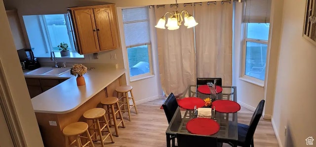 1004 N Sir Michael Dr, Salt Lake City, UT 84116 - dining space featuring a chandelier, light wood-style floors, plenty of natural light, and baseboards