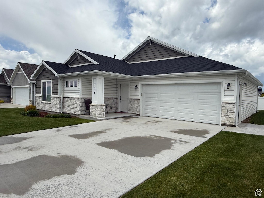269 W 520 S, Hyde Park, UT 84318 - view of front of property with stone siding, a garage, driveway, a front yard, and a shingled roof