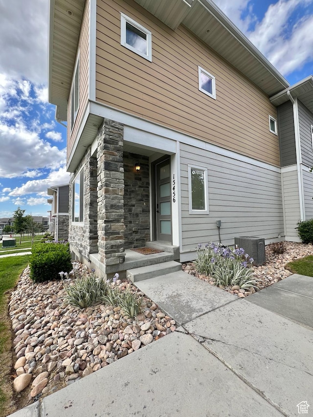15456 S Navy Trails Ln W, Bluffdale, UT 84065 - view of exterior entry with central AC and stone siding