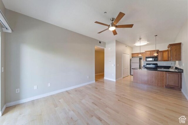 1134 E 3300th St S Unit 416, Salt Lake City, UT 84106 - kitchen featuring stainless steel appliances, brown cabinetry, ceiling fan, open floor plan, and light wood-type flooring
