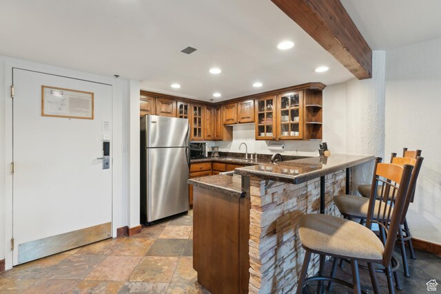 1485 Empire Ave Unit 201, Park City, UT 84060 - kitchen featuring freestanding refrigerator, brown cabinetry, a sink, a peninsula, and baseboards