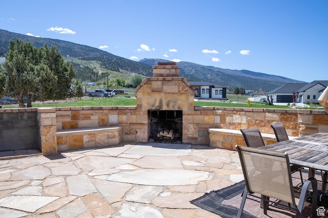 954 E 960 S, Ephraim, UT 84627 - view of patio / terrace featuring an outdoor stone fireplace, a mountain view, and outdoor dining space