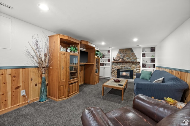 475 E 6815 S, Midvale, UT 84047 - living area with dark colored carpet, wainscoting, a stone fireplace, wooden walls, and built in shelves