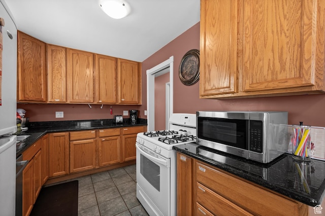 475 E 6815 S, Midvale, UT 84047 - kitchen featuring white appliances, tile patterned flooring, dark stone counters, and brown cabinetry