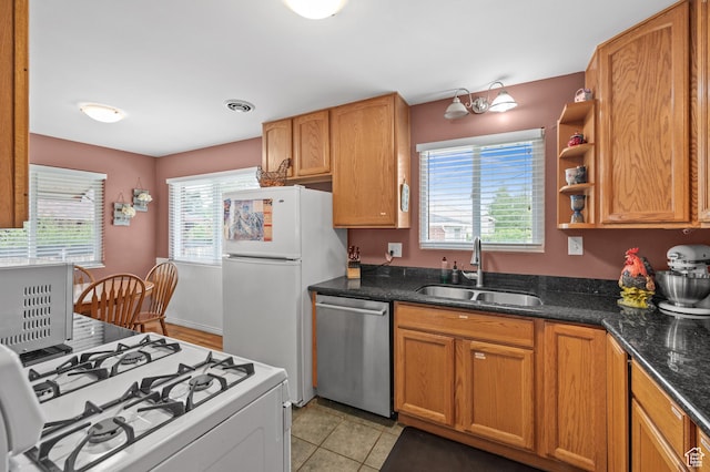 475 E 6815 S, Midvale, UT 84047 - kitchen with white appliances, a sink, dark stone counters, brown cabinetry, and light tile patterned floors
