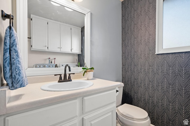 2276 W Bonniebrook Cir S, Taylorsville, UT 84129 - bathroom featuring wallpapered walls, an accent wall, toilet, and vanity