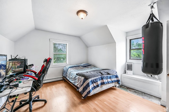 201 S 400 W, Logan, UT 84321 - bedroom with lofted ceiling, wood finished floors, and a baseboard heating unit