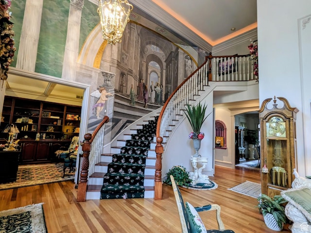 6331 S Shenandoah Ave, Salt Lake City, UT 84121 - staircase featuring a towering ceiling, wood finished floors, a chandelier, and ornamental molding