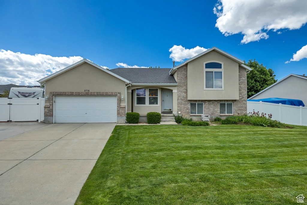 9736 S Rosewood Ct W, South Jordan, UT 84095 - tri-level home featuring stucco siding, a garage, concrete driveway, and a gate