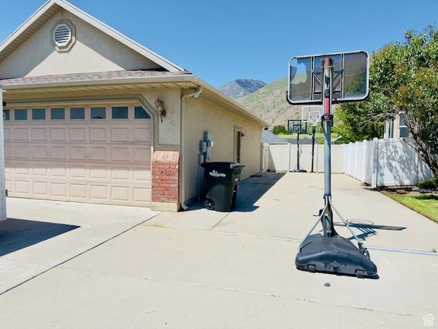 1965 E River Bottom Rd S, Springville, UT 84663 - view of side of property with a mountain view, stucco siding, concrete driveway, a garage, and brick siding