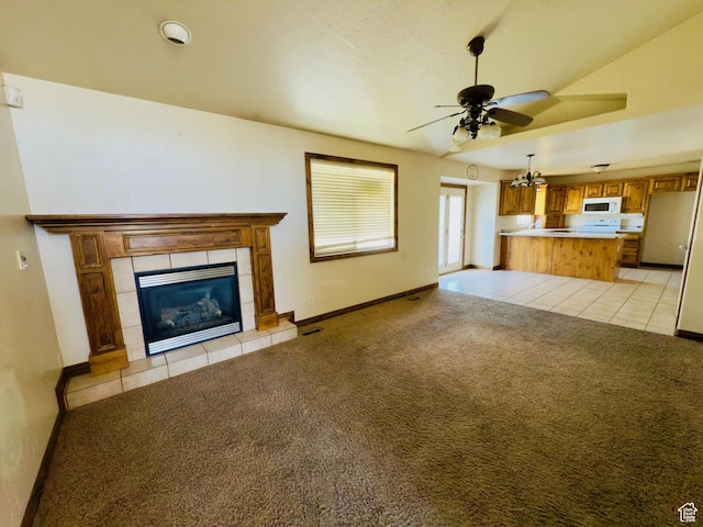 1965 E River Bottom Rd S, Springville, UT 84663 - unfurnished living room with light carpet, a ceiling fan, a tiled fireplace, light tile patterned flooring, and baseboards
