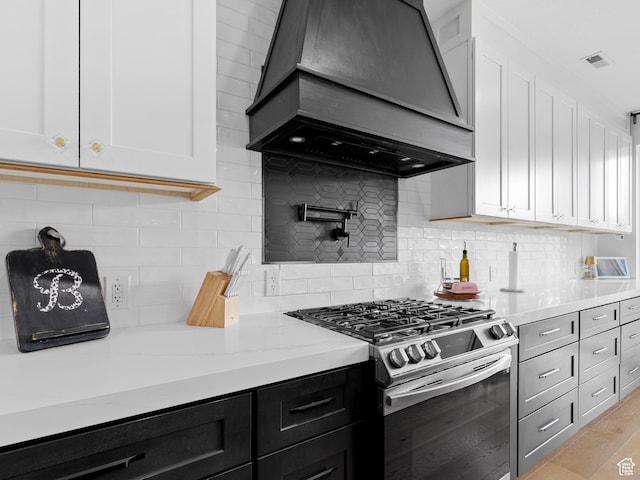 2083 N Elderberry Dr, Saratoga Springs, UT 84045 - kitchen featuring stainless steel gas range, custom range hood, white cabinets, light stone countertops, and tasteful backsplash