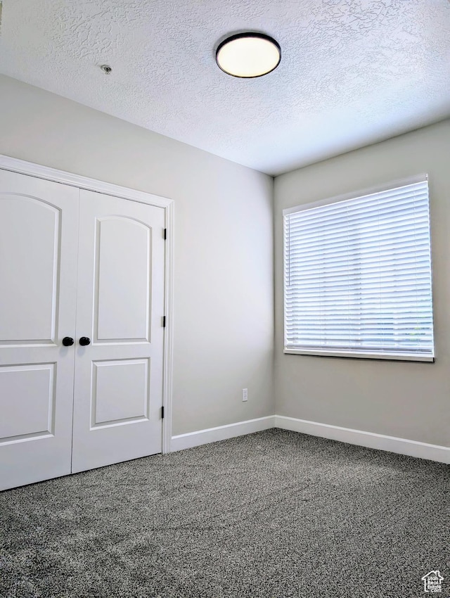 1030 N 995 W Unit 907, Orem, UT 84057 - unfurnished bedroom with carpet flooring, baseboards, a closet, and a textured ceiling