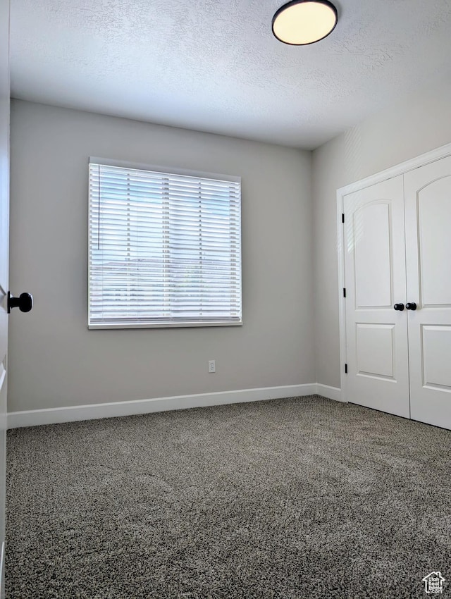 1030 N 995 W Unit 907, Orem, UT 84057 - unfurnished bedroom featuring a closet, baseboards, carpet floors, and a textured ceiling