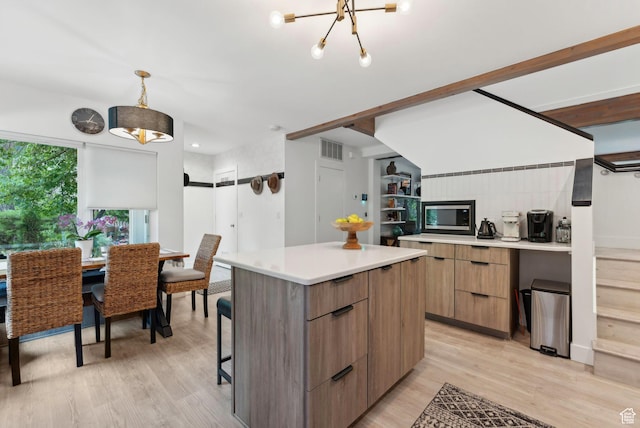 1411 S Utah St Unit 7, Salt Lake City, UT 84104 - kitchen featuring modern cabinets, a kitchen island, stainless steel microwave, light wood-style flooring, and light countertops