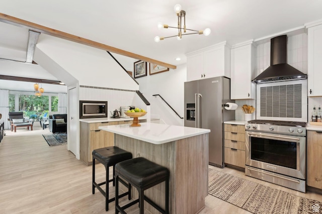1411 S Utah St Unit 7, Salt Lake City, UT 84104 - kitchen featuring appliances with stainless steel finishes, wall chimney range hood, a chandelier, and light wood-type flooring