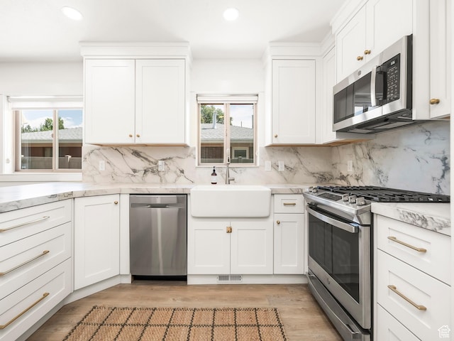 1136 E 3580 S, Millcreek, UT 84106 - kitchen with appliances with stainless steel finishes, a sink, backsplash, recessed lighting, and white cabinets