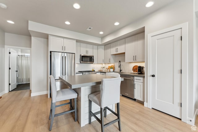 6625 Mountain Alder Way Unit 24, Park City, UT 84098 - kitchen featuring appliances with stainless steel finishes, a kitchen breakfast bar, a sink, light wood finished floors, and a center island
