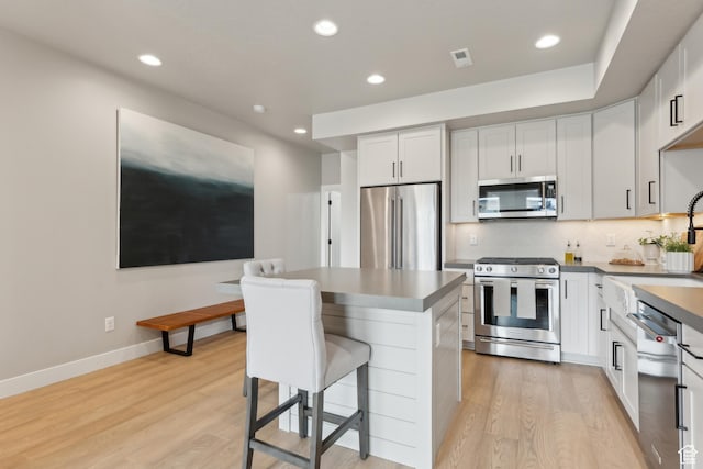 6625 Mountain Alder Way Unit 24, Park City, UT 84098 - kitchen with appliances with stainless steel finishes, light wood finished floors, a breakfast bar area, recessed lighting, and a sink