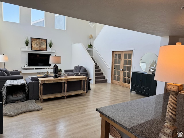 144 E Shorewood Dr S, Saratoga Springs, UT 84045 - living area with light wood-type flooring, stairs, and french doors