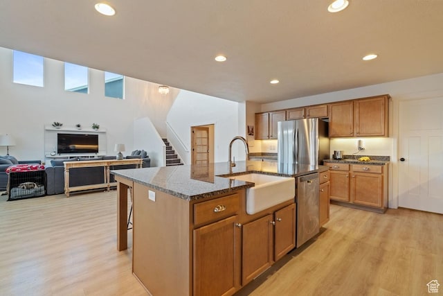 144 E Shorewood Dr S, Saratoga Springs, UT 84045 - kitchen featuring appliances with stainless steel finishes, a sink, light wood finished floors, recessed lighting, and dark stone countertops