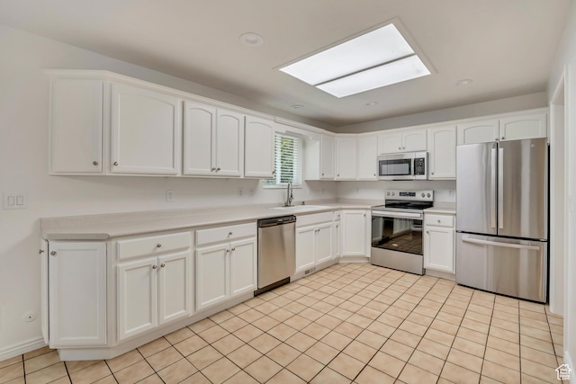 8328 S Grambling Way, Sandy, UT 84094 - kitchen featuring stainless steel appliances, a sink, a skylight, white cabinetry, and light countertops