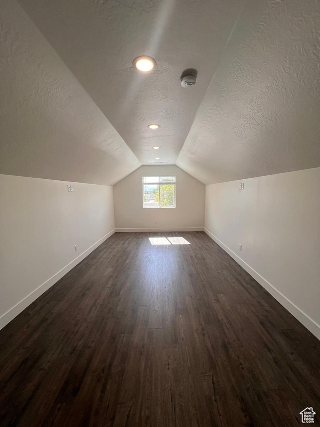 502 N 450 W, Orem, UT 84057 - additional living space with a textured ceiling, baseboards, vaulted ceiling, and dark wood finished floors