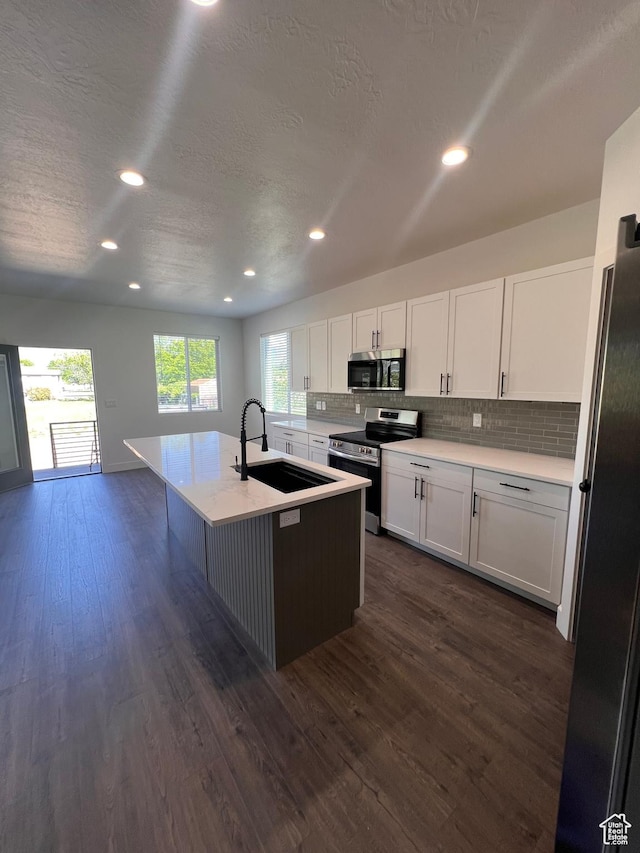 502 N 450 W, Orem, UT 84057 - kitchen featuring appliances with stainless steel finishes, a sink, backsplash, white cabinets, and dark wood finished floors