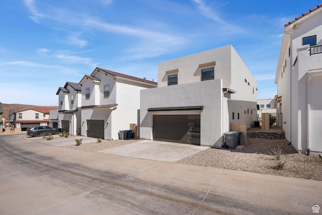 5670 S Carnelian Pkwy S, Bloomington, UT 84790 - view of property exterior featuring a garage, a residential view, concrete driveway, and stucco siding
