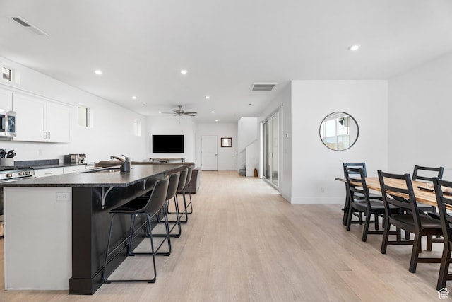 5670 S Carnelian Pkwy S, Bloomington, UT 84790 - kitchen with stainless steel appliances, a sink, dark countertops, an island with sink, and ceiling fan