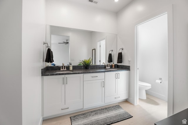 5670 S Carnelian Pkwy S, Bloomington, UT 84790 - full bathroom featuring double vanity, toilet, baseboards, wood finished floors, and ceiling fan