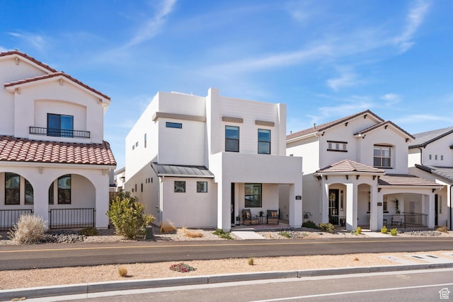 5670 S Carnelian Pkwy S, Bloomington, UT 84790 - view of front of house featuring covered porch, stucco siding, a balcony, and a tile roof