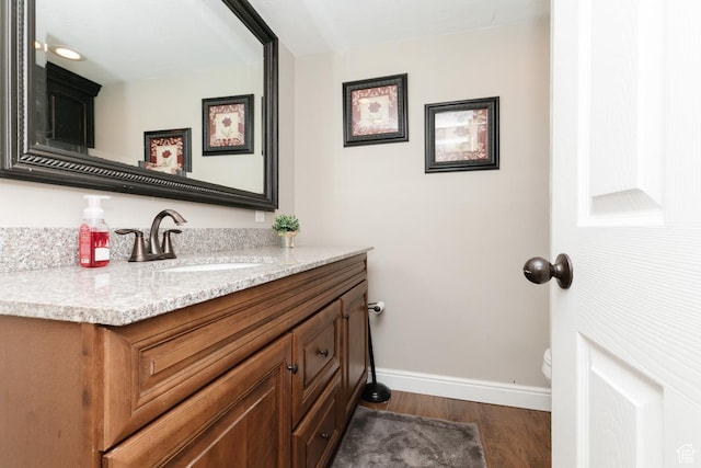 3704 S State St, Preston, ID 83263 - bathroom featuring wood finished floors, baseboards, vanity, and toilet
