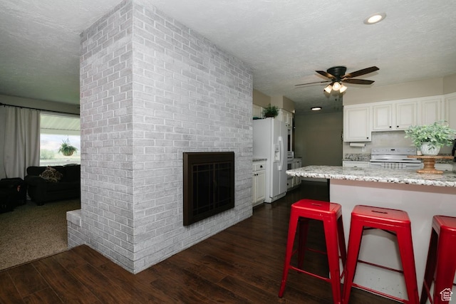 3704 S State St, Preston, ID 83263 - kitchen with white appliances, dark wood finished floors, ceiling fan, white cabinets, and a textured ceiling