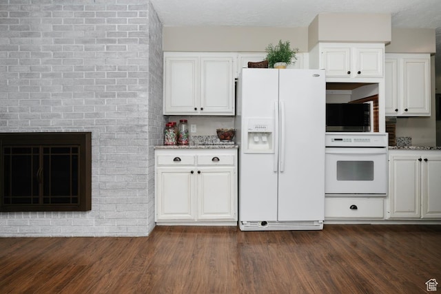 3704 S State St, Preston, ID 83263 - kitchen featuring white appliances, white cabinets, dark wood-type flooring, and light stone counters